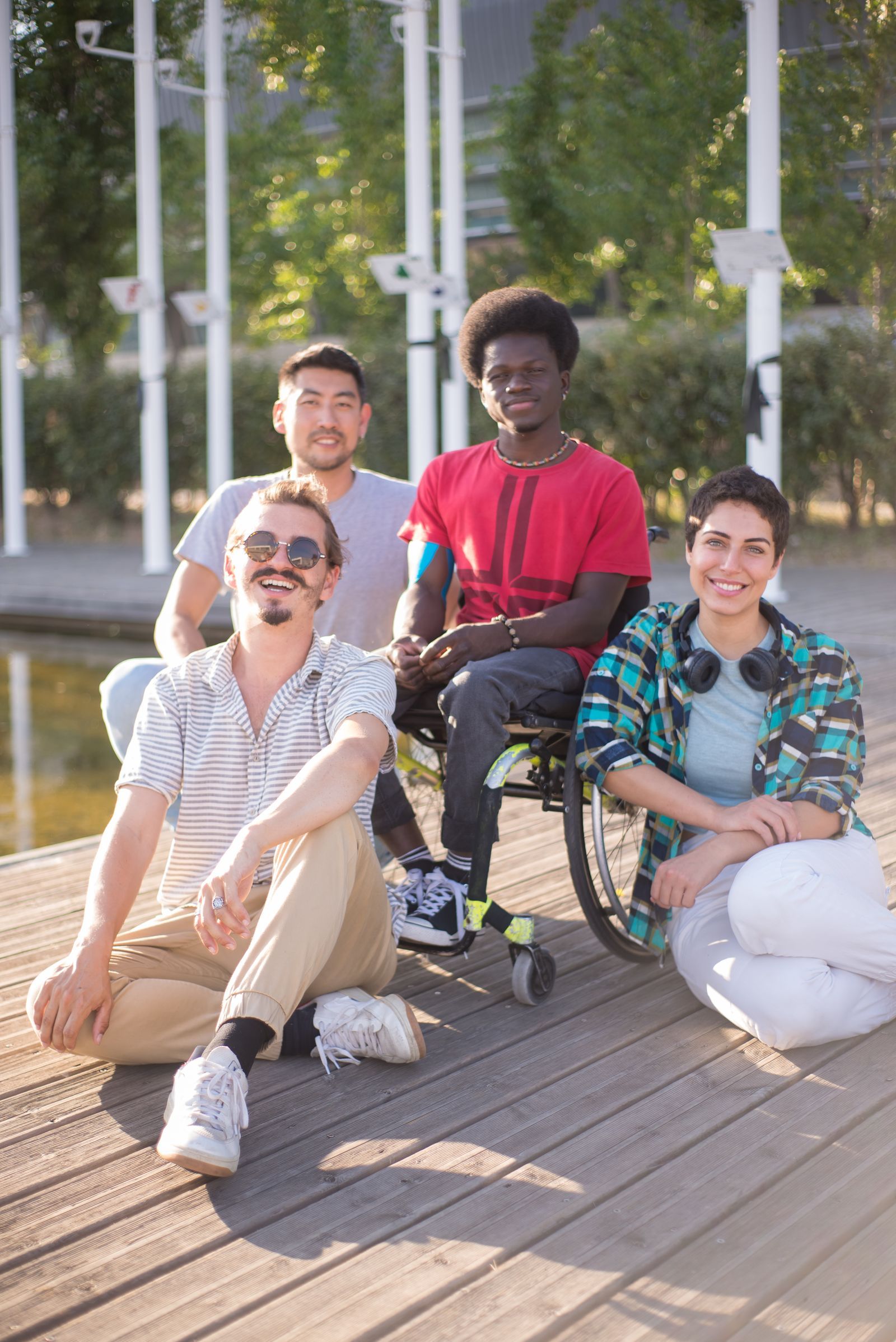 A young man in a wheelchair smiling with friends
